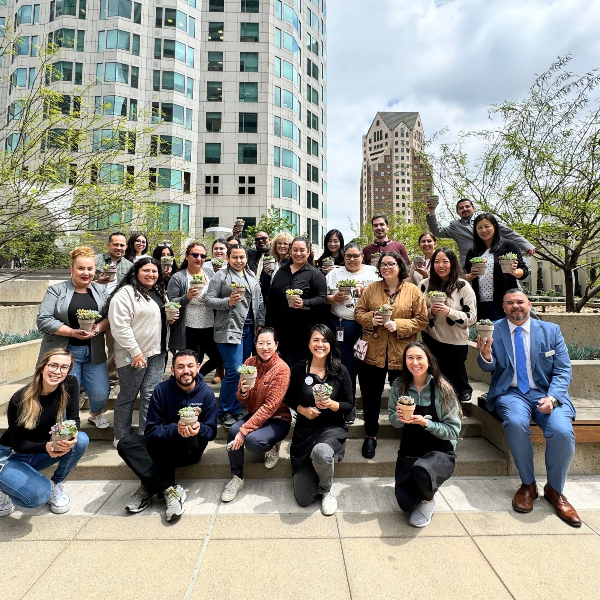 Corporate workshop group in downtown LA holding the succulent pots they planted